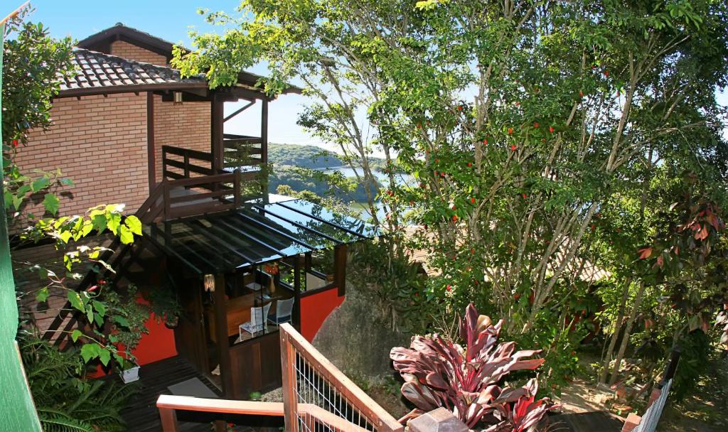 ein Haus mit einem Balkon in einem Garten in der Unterkunft Morada da Lagoa in Praia do Rosa