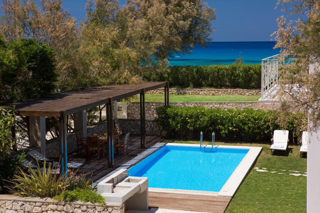 a swimming pool in a backyard with a wooden deck and a swimming pool at Aeriko Homes of Distinction in Lefkada