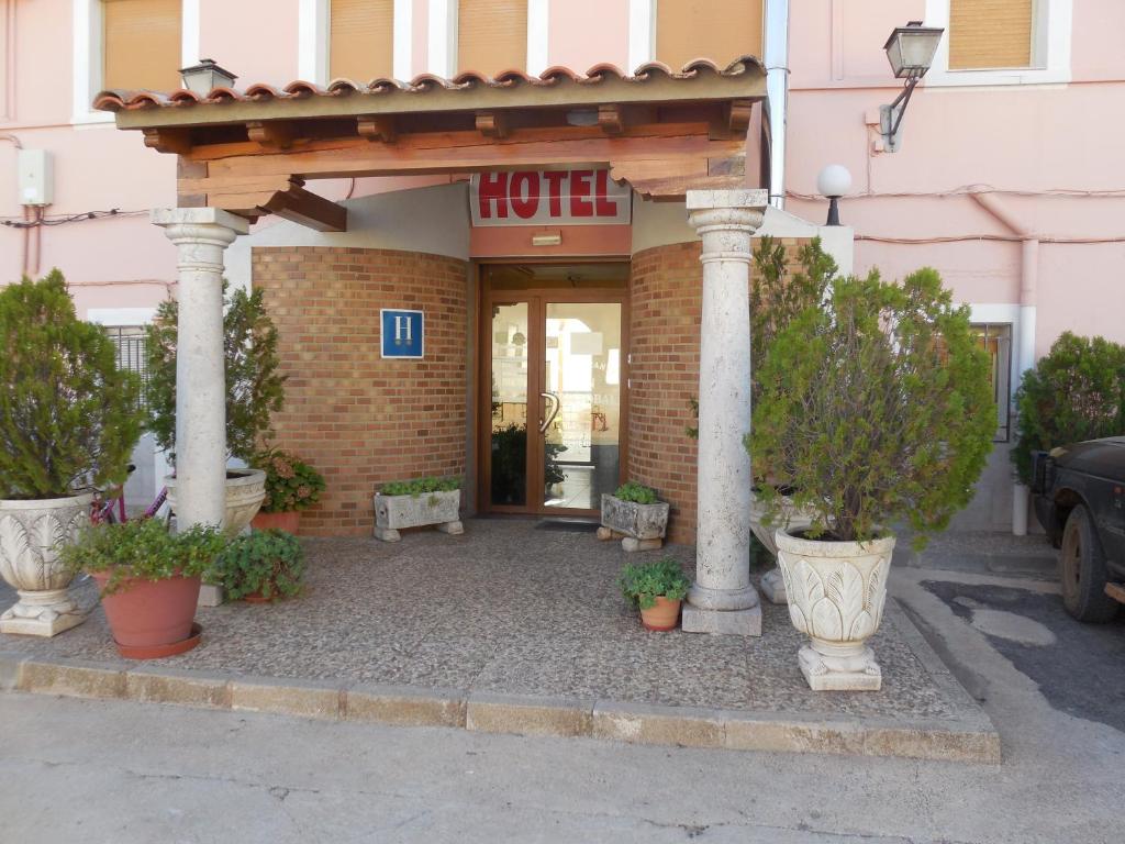 una entrada de hotel con pilares y plantas delante de ella en San Cristobal, en Villahermosa
