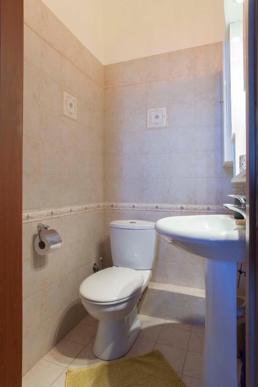 Łazienka z białą toaletą i umywalką w obiekcie Aegina Villa Kalliopi w mieście Egina