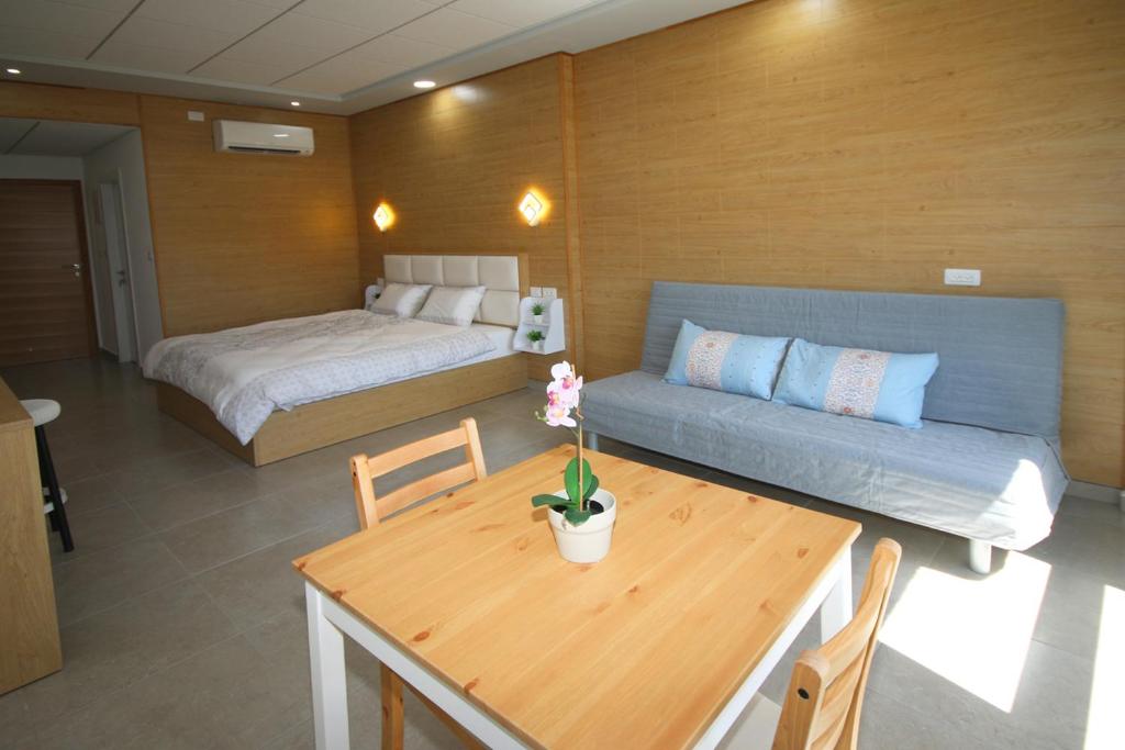 Habitación con sofá, mesa y cama en סנו נופש בגולן, en Majdal Shams