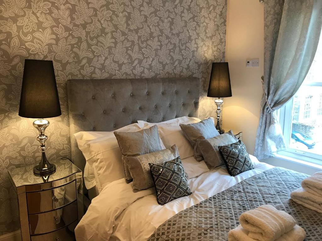 a bedroom with a bed with pillows and a window at Millwalk Apartment in Witney