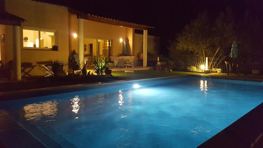 a swimming pool at night with a house at Villa La Croisette in Sainte-Maxime