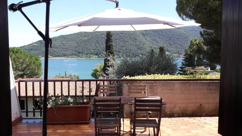 サルニコにあるTerrazza sul lago di Iseoのパティオ(テーブル、椅子、パラソル付)