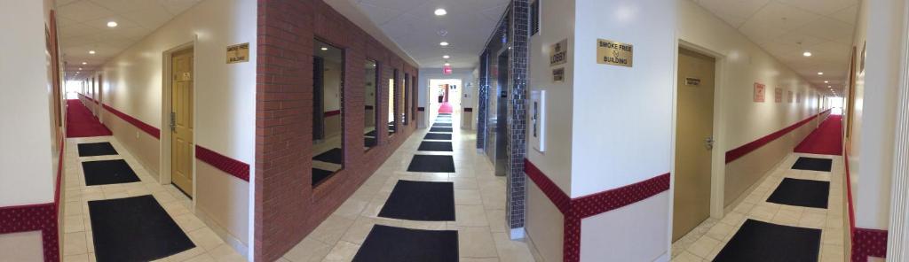 a hallway with black and white floors in a building at New Imperial Suites in Whitecourt