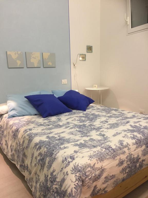 - un lit avec des oreillers bleus dans une chambre dans l'établissement Casa Pervinca, à Chiavari