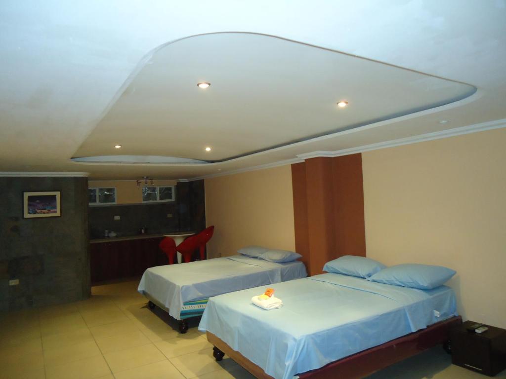 a hotel room with two beds and a kitchen at Hostaling Guayaquil Trabajo in Mercedes