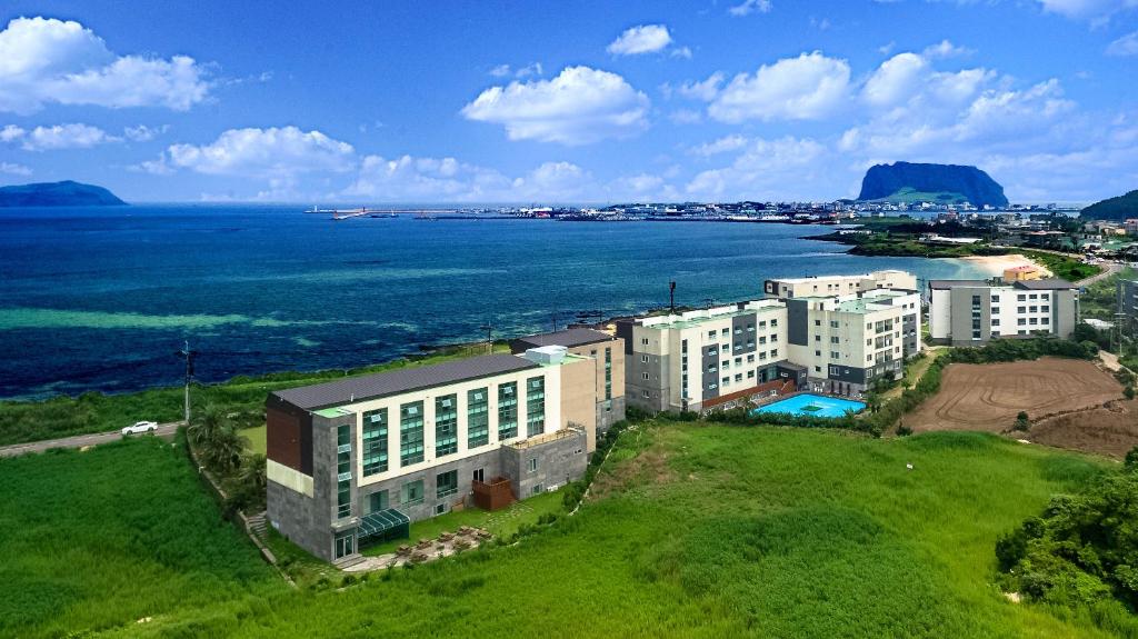 Jeju Arumdaun Resort في سيوجويبو: اطلالة جوية على مبنى مجاور للمحيط