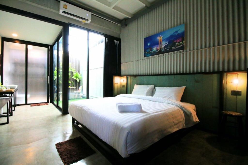 a bedroom with a large bed and a large window at THE TREE Sleep and Space in Trang