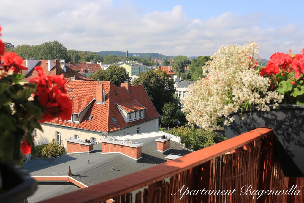 uma vista para a cidade a partir de uma varanda com telhados vermelhos em Bugenwilla Apartament em Sopot