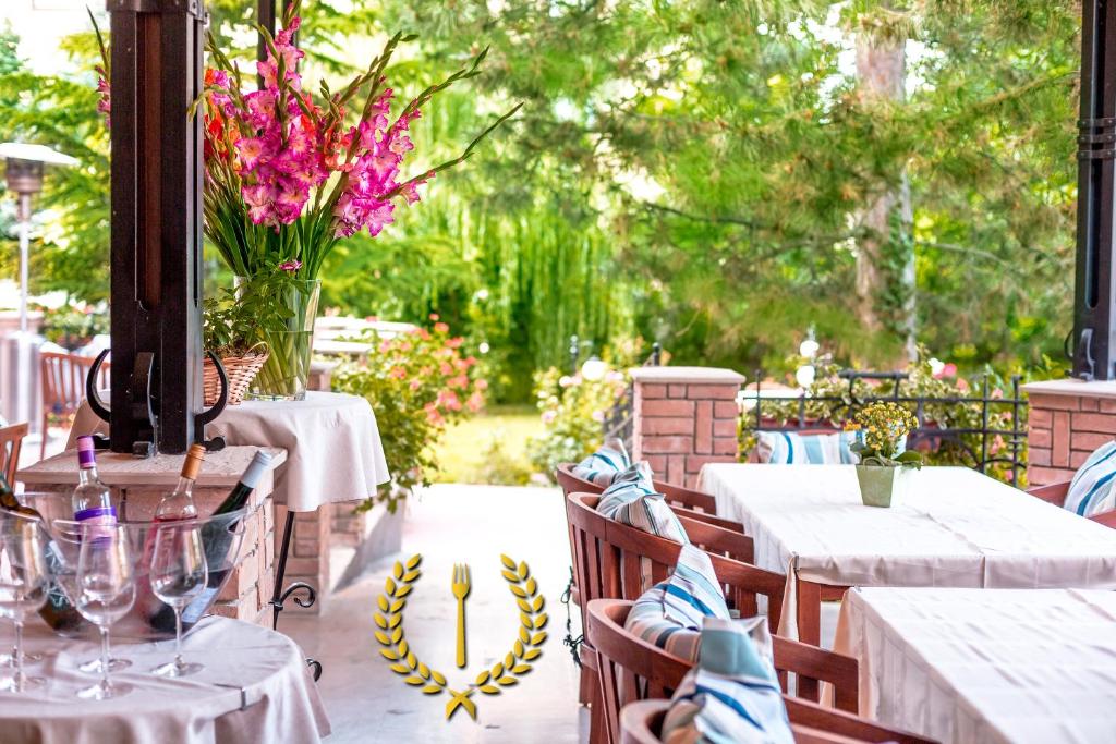 un patio con mesas y sillas con flores. en Villa Rosa, en Dunajská Streda