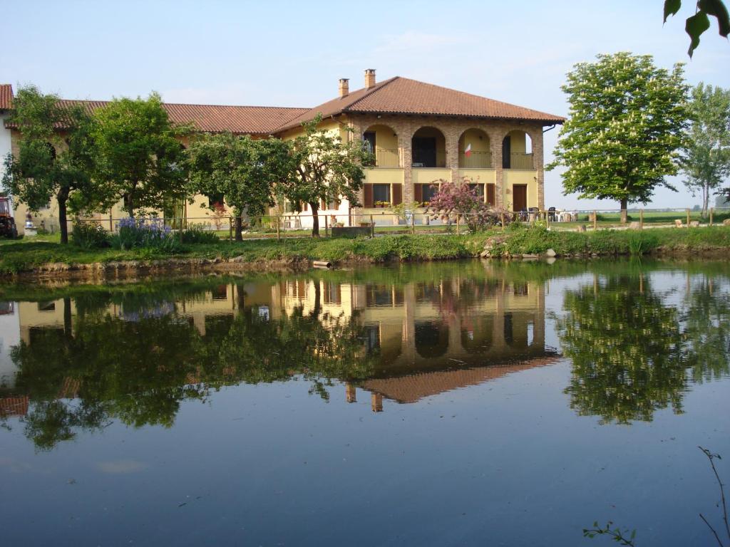 a house with a reflection in the water at Agriturismo La Cinciallegra in Riva presso Chieri