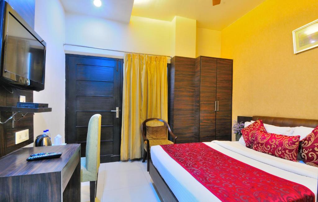 a bedroom with a bed and a desk and a television at Hotel Central Park 17 in Chandīgarh