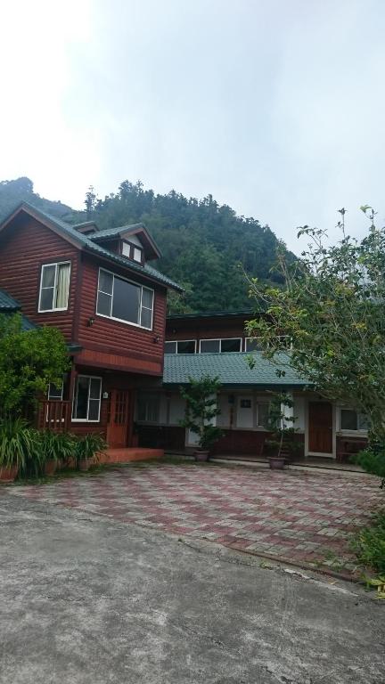 uma grande casa de madeira com uma grande entrada em Xin Cai Homestay em Meishan