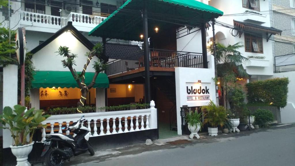 un scooter estacionado frente a un edificio en Bladok Hotel & Restaurant, en Yogyakarta