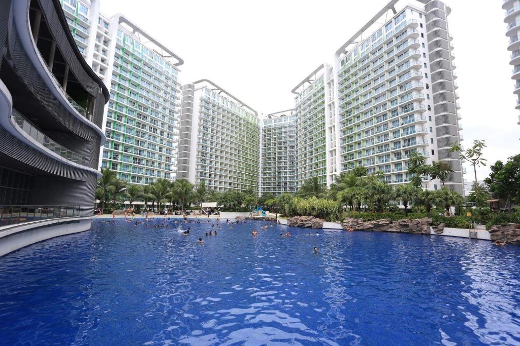ein Schwimmbad vor einigen hohen Gebäuden in der Unterkunft Maui Condotel Azure Residence in Manila
