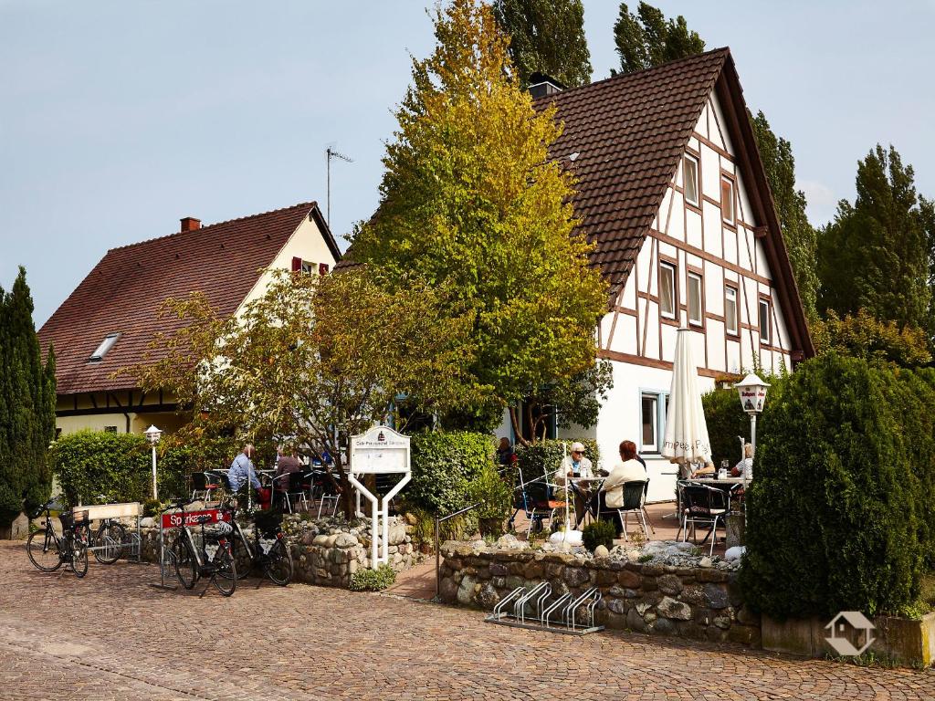 eine Gruppe von Personen, die außerhalb eines Gebäudes sitzen in der Unterkunft Café Perlmuschel in Iznang