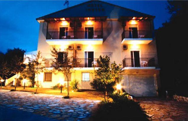 una gran casa blanca con luces encendidas por la noche en Ionion Hotel, en Sivota