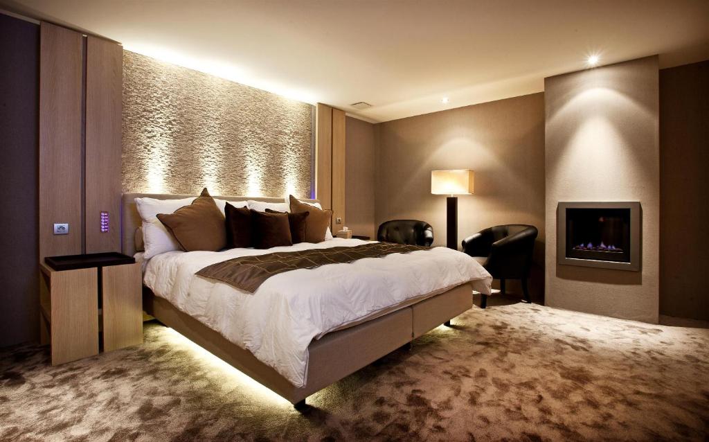 una camera con un grande letto e una TV di Hotel Thermen Dilbeek a Dilbeek