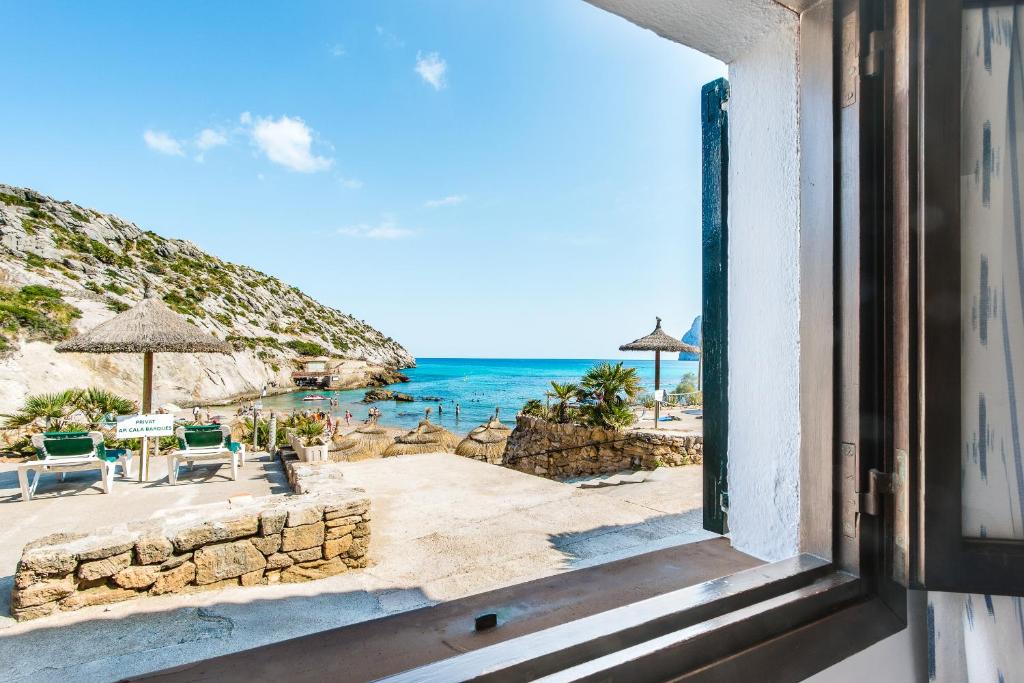 una ventana con vistas a la playa en Blue fisherman house 2 By homevillas360, en Cala de Sant Vicent