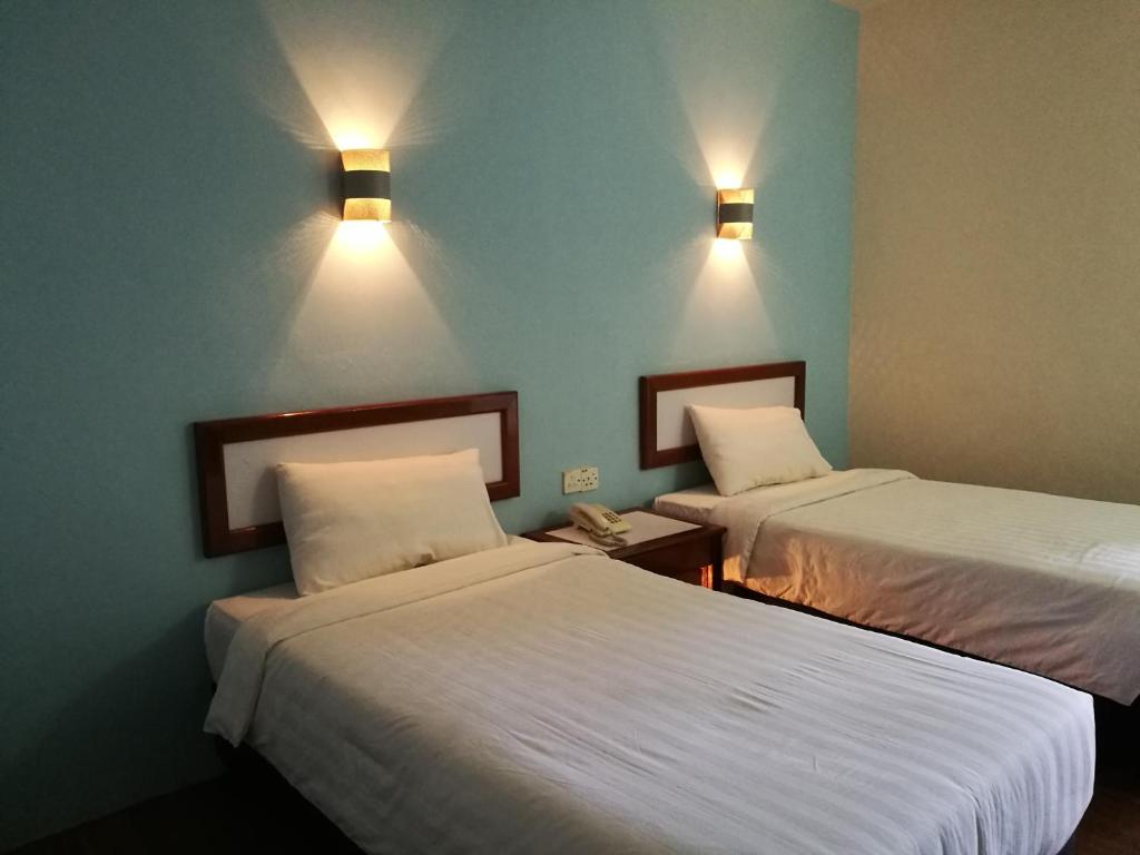 - 2 lits dans une chambre d'hôtel avec des lumières sur le mur dans l'établissement Hotel Ipoh City, à Ipoh