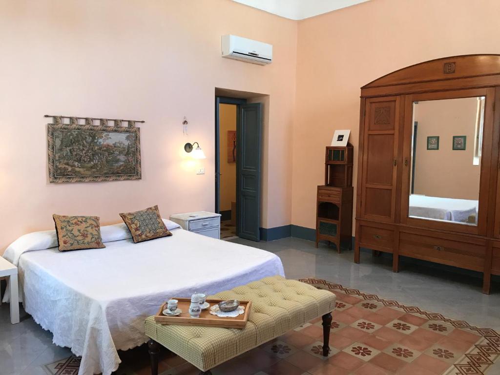 a bedroom with a large white bed and a dresser at Town View in Noto