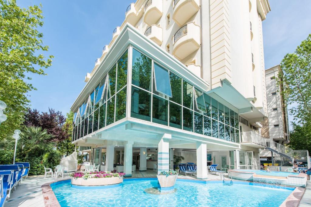 an exterior view of a building with a pool at Michelangelo Cesenatico in Cesenatico