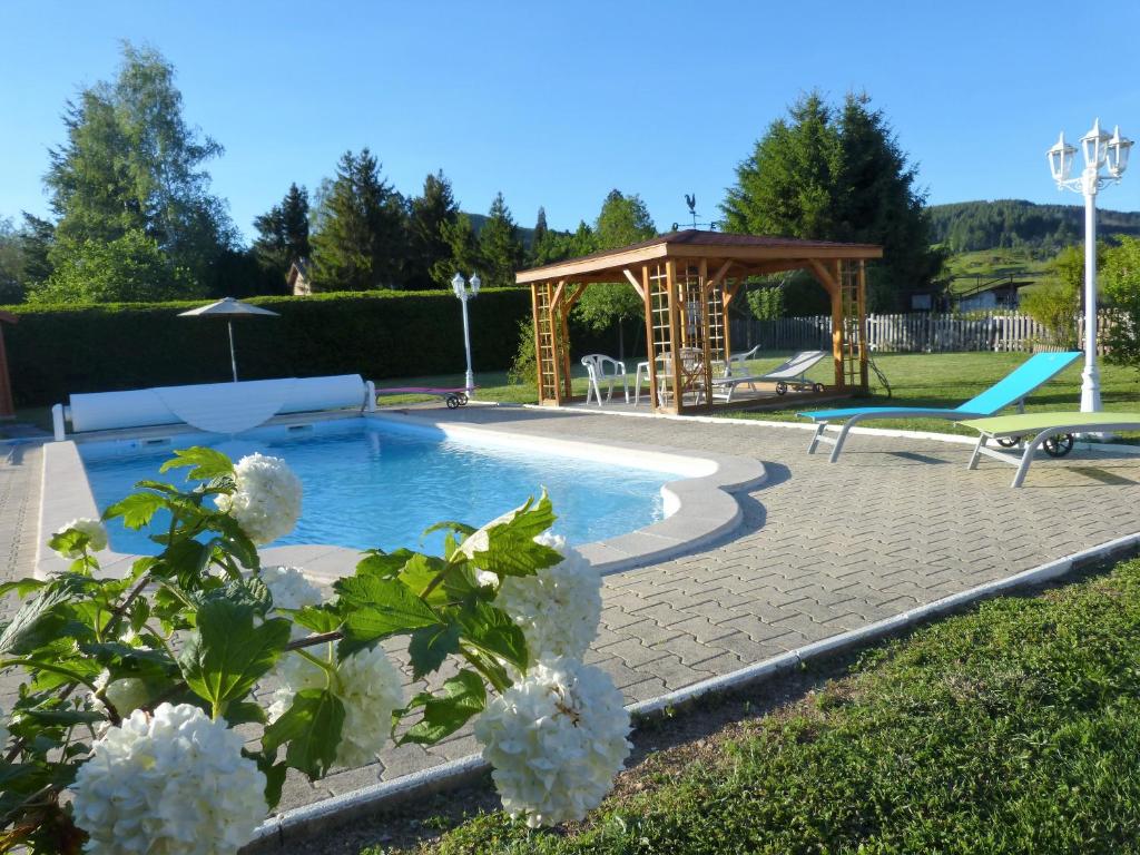 einen Pool mit einem Pavillon und einer Bank in der Unterkunft La Campagnarde in Saint-Just-en-Chevalet