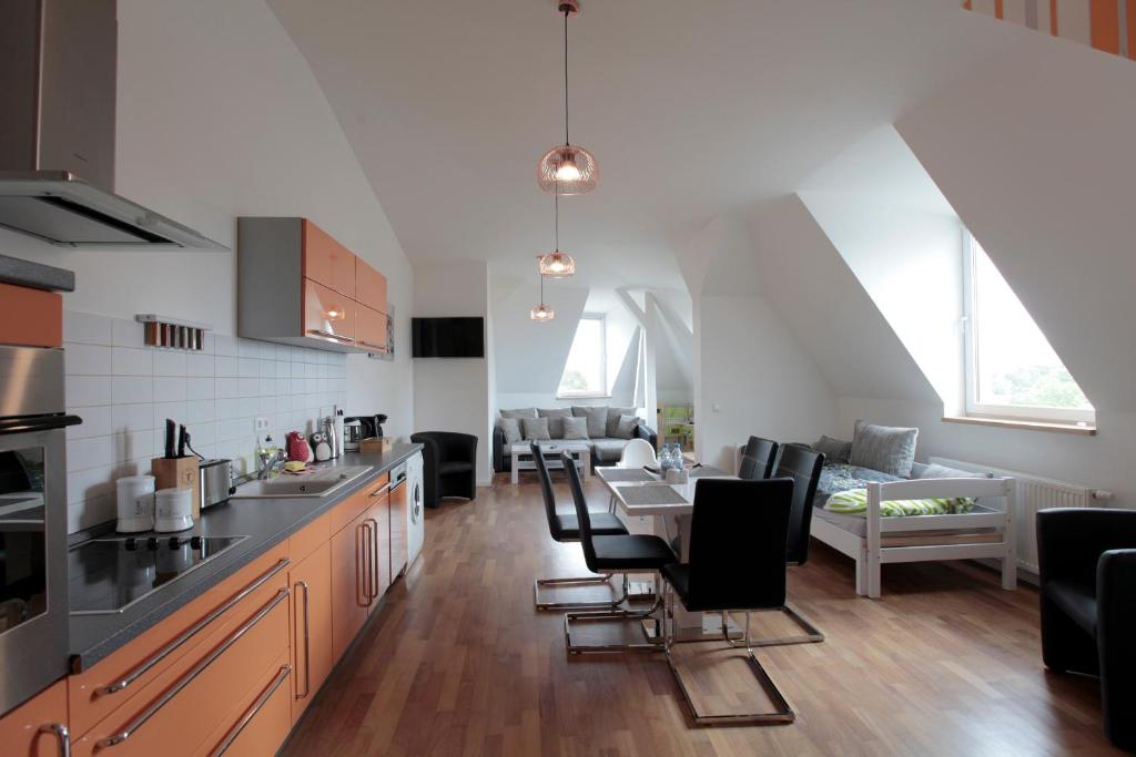 a kitchen and living room with a table and chairs at Loftapartment Süd in Leipzig