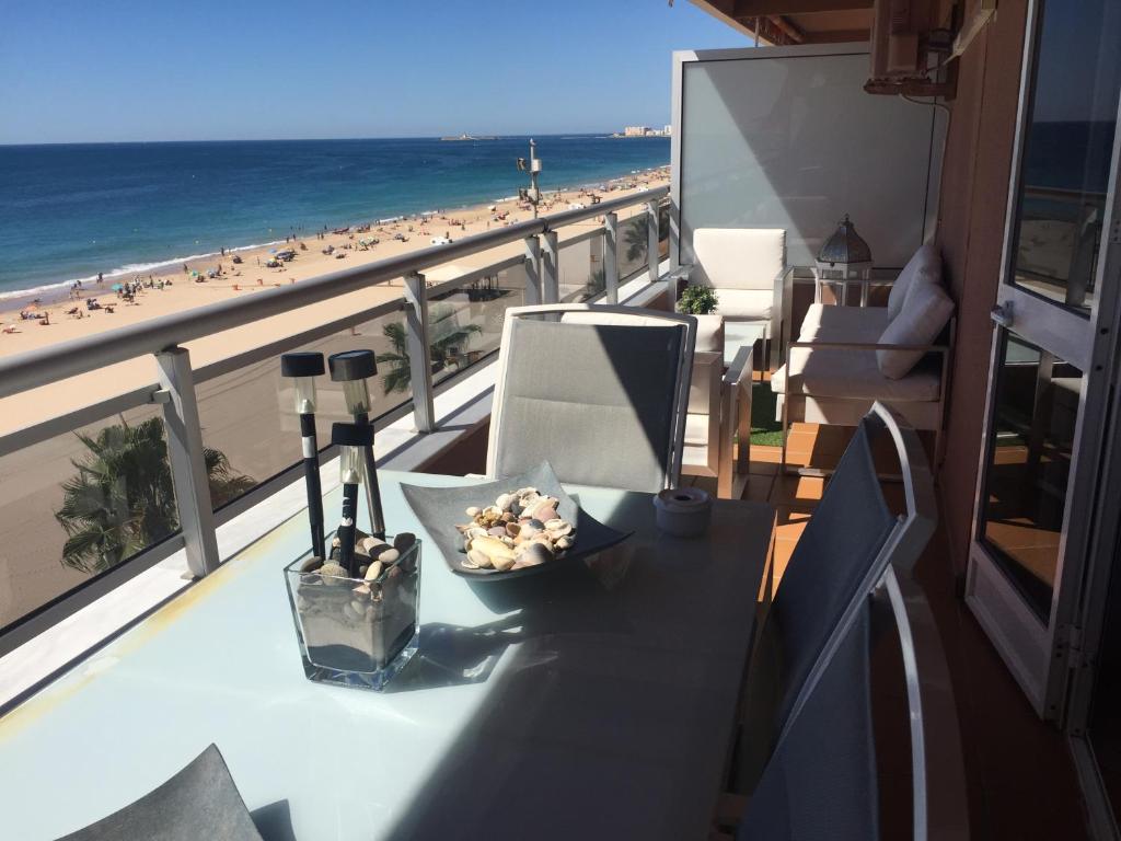 a table on a balcony with a view of the beach at Luxury Oceanfront triplex in Cadiz in Cádiz
