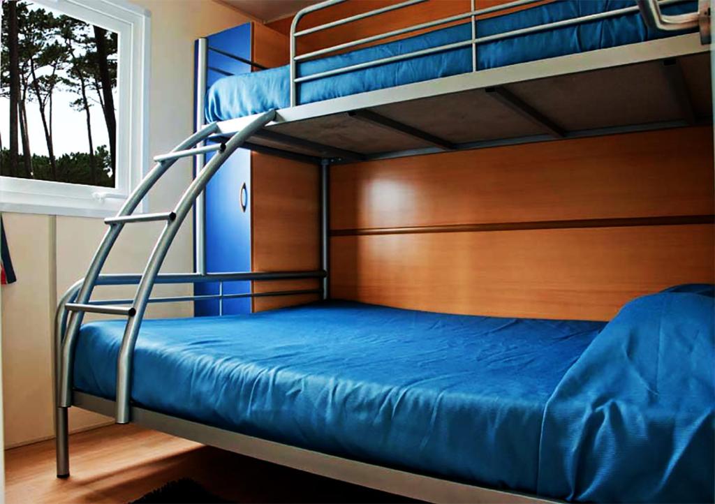 Двухъярусная кровать или двухъярусные кровати в номере Parque de Campismo Orbitur Costa de Caparica