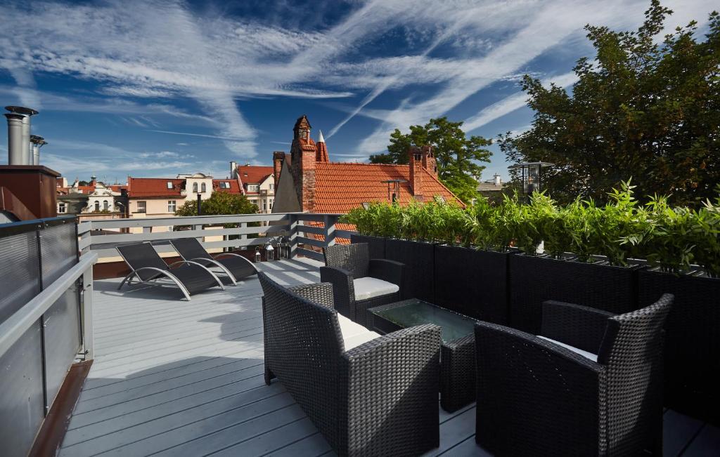 a balcony with chairs and tables on a roof at Victus Apartamenty, Apartamenty Delux in Sopot