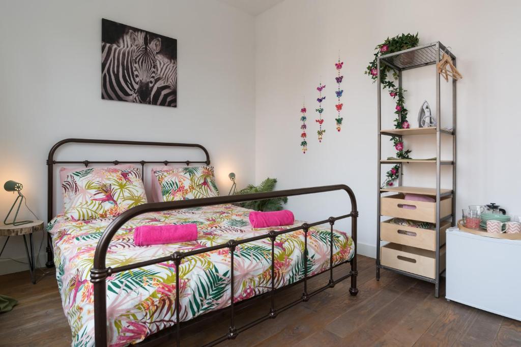 a bedroom with a metal bed with colorful pillows at Stir It Up Studio in Amsterdam
