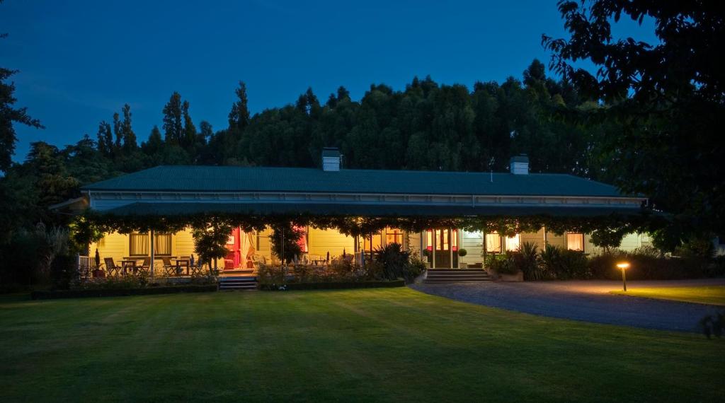 a house with a pavilion in a yard at night at The Peppertree Luxury Accommodation in Blenheim