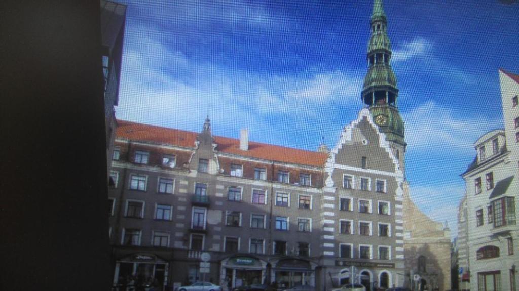 un gran edificio con una torre de reloj encima en Apartment Kalku 2, en Riga
