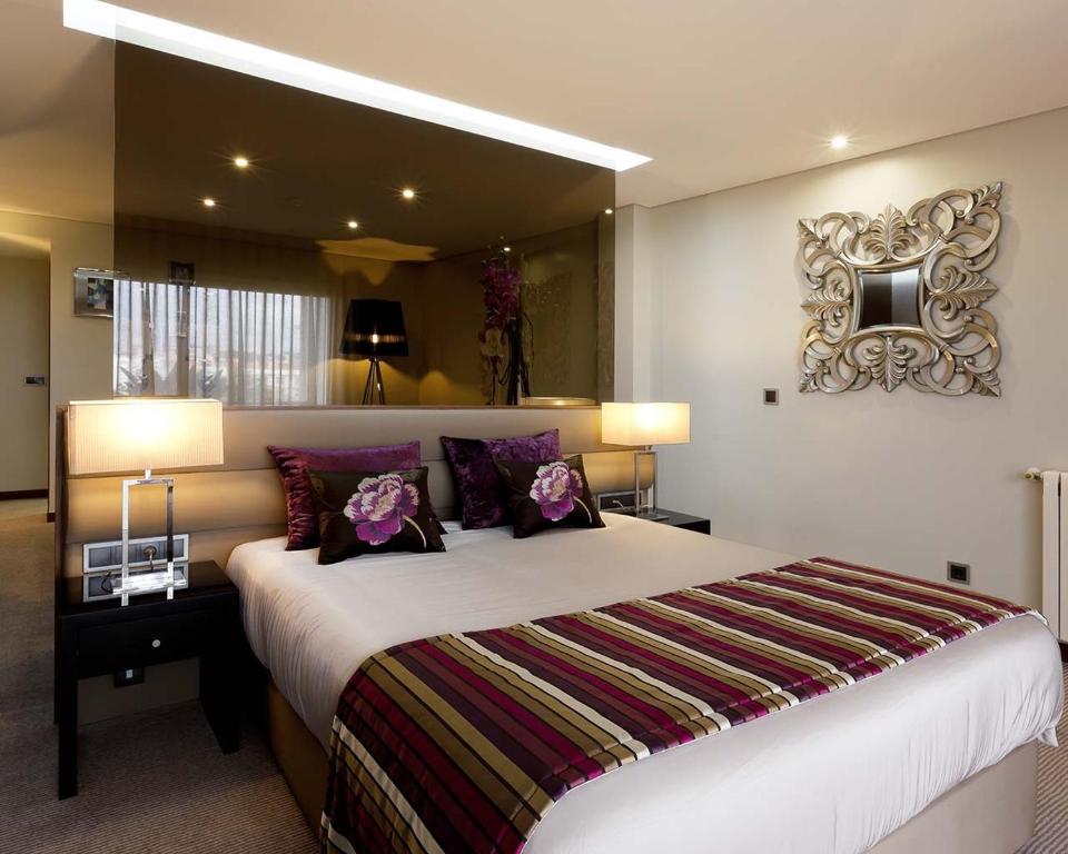 a bedroom with a large bed with purple pillows at Cardal Hotel in Pombal