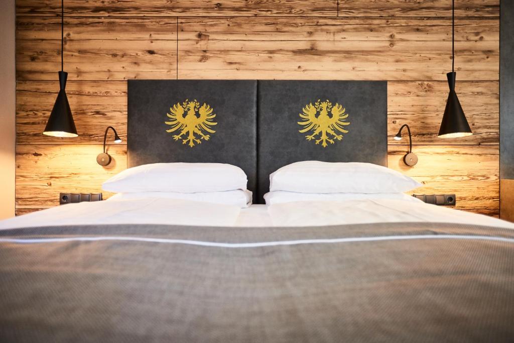 a bedroom with a large bed with two white pillows at Der Postwirt in Söll