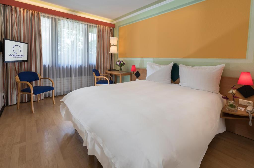 Postel nebo postele na pokoji v ubytování Hotel Parc Belle-Vue