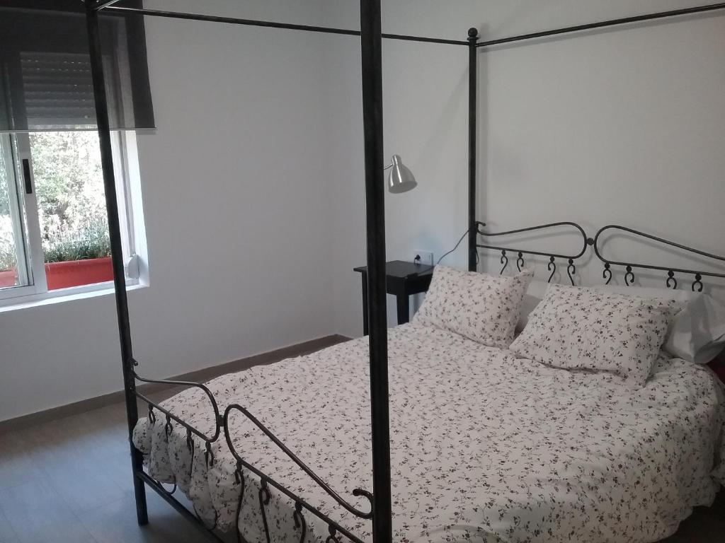 a bedroom with a black canopy bed with pillows at New Trendy apartment in Valencia