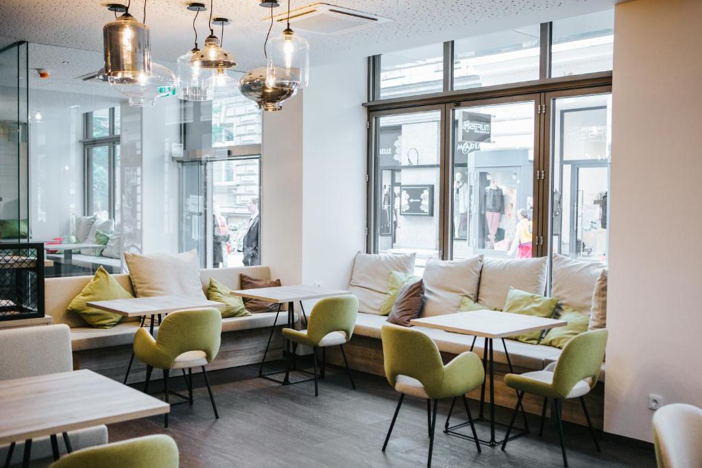 un restaurante con mesas, sillas y ventanas en Hotel Schwarzer Bär, en Linz