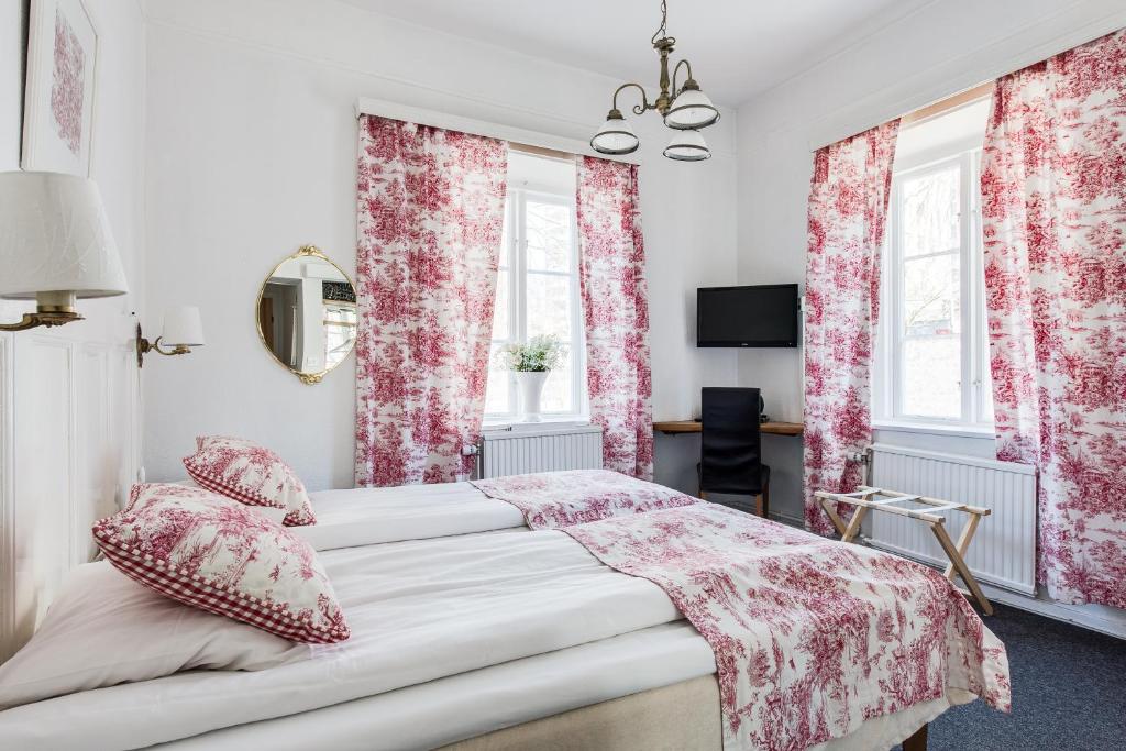 a bedroom with pink floral curtains and a bed at Wow Apartments Örgryte in Gothenburg