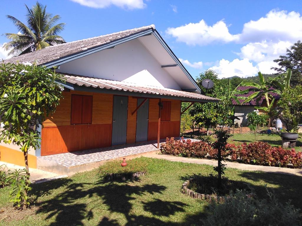 una pequeña casa en un jardín con patio en Ban Suan Sukjai Mae Sariang, en Mae Sariang