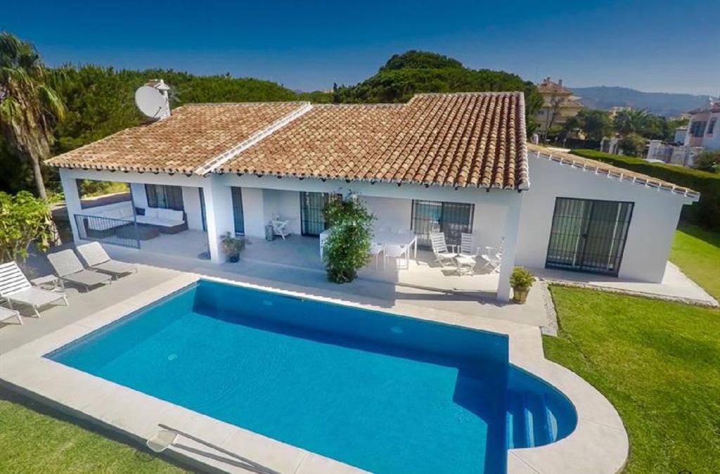 a villa with a swimming pool in front of a house at Great Villa Near Beach and Marbella in Marbella