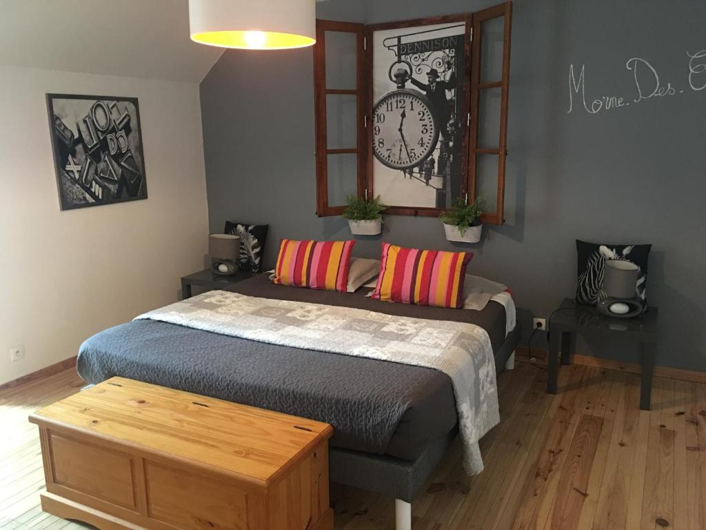 a bedroom with a bed and a clock on the wall at Madinina'S Cube in Saint-Aignan