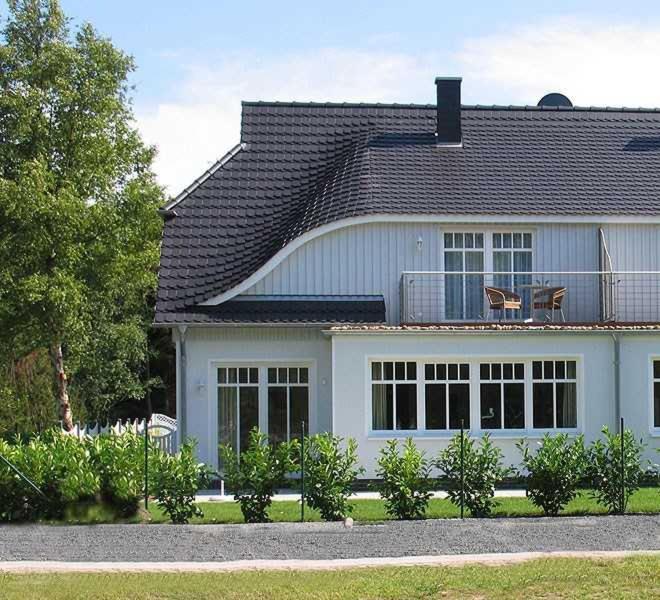 a white house with a black roof at Ferienhaus Sundevit Nr 1 Prerow in Prerow
