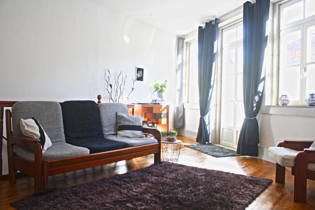 ein Wohnzimmer mit einem Sofa und einigen Fenstern in der Unterkunft Casa Azul d'Altamira in Viana do Castelo