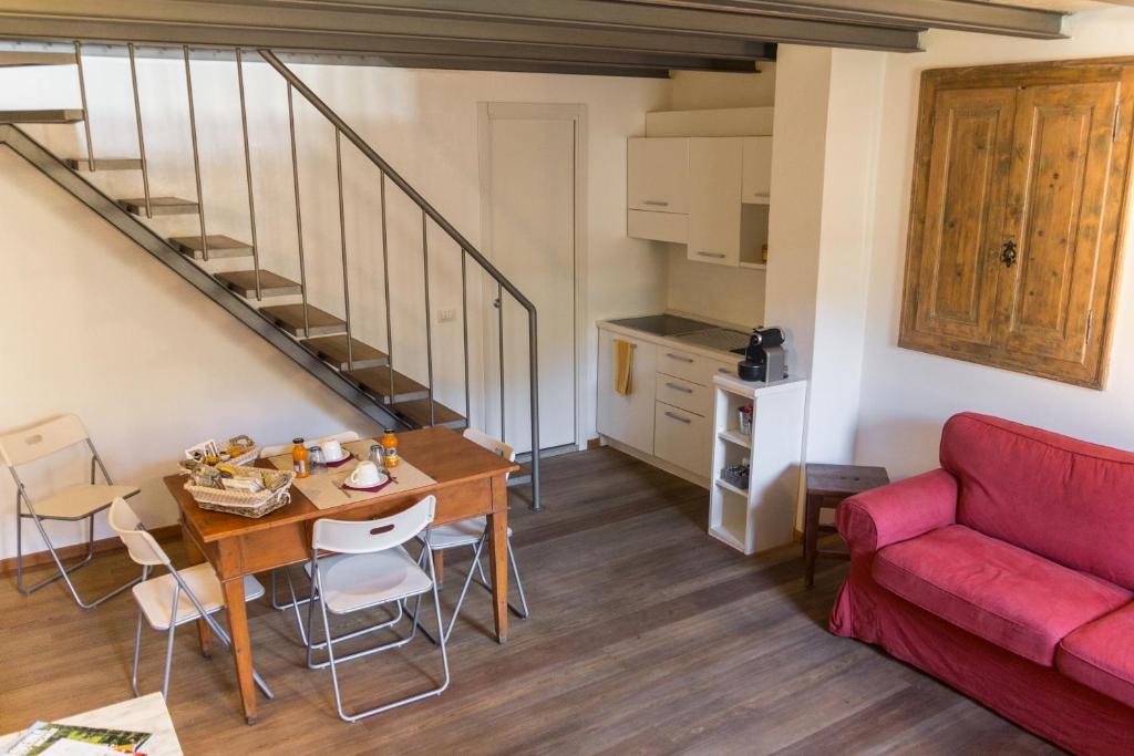 a living room with a table and a red couch at La Sciora Oliva in Chiavenna