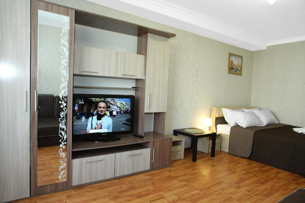 sala de estar con TV y cama en Apartment on Elninskay 18 en Moscú