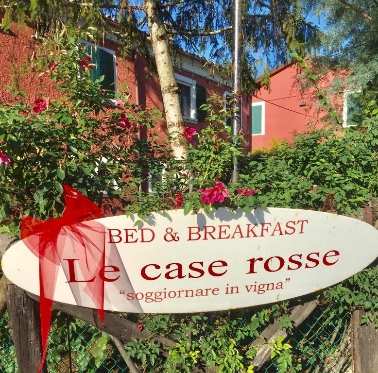 Un cartel que lee "Bed and Breakfast Ice House" y una tabla de surf. en BeB LE CASE ROSSE, en Verucchio