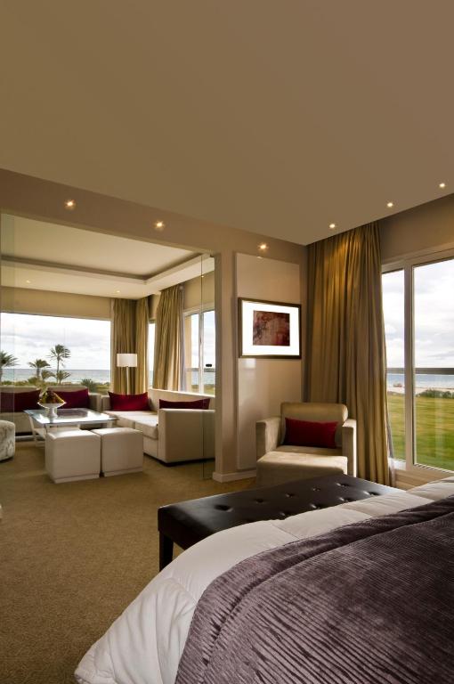 a hotel room with a bed and a living room at Royal Thalassa Monastir in Monastir